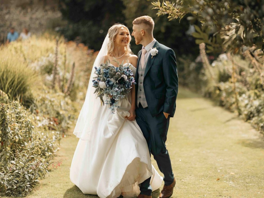 A bride and groom standing in a garden